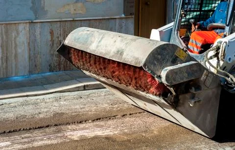 Sweeper attachments mini excavator. The sweeper sweeps, collects and dumps di Stock Photos
