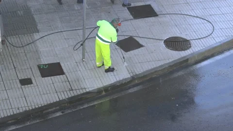 Sweeper cleaning a city sidewalk with high pressure washing machine Video stock 170049255