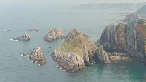 A sweeping aerial shot captures the dramatic rocky coastline near Cudillero Stock Footage 346693010