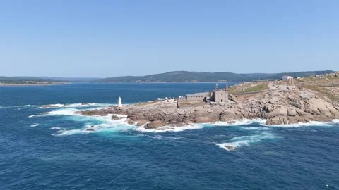 A sweeping aerial shot captures the dramatic coastline at Faro de Muxia, Spain Stock Footage 346713054