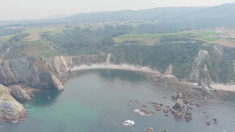 A sweeping aerial shot captures the dramatic cliffs and tranquil bay of Playa Stock Footage 346722036