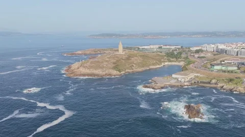 A sweeping aerial shot captures the iconic Torre de Hercules lighthouse standing Stock Footage 346715927