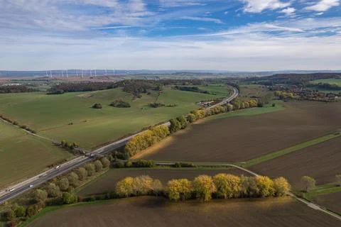Sweeping aerial view of highway interchange winding through autumn farmland Stock Photos