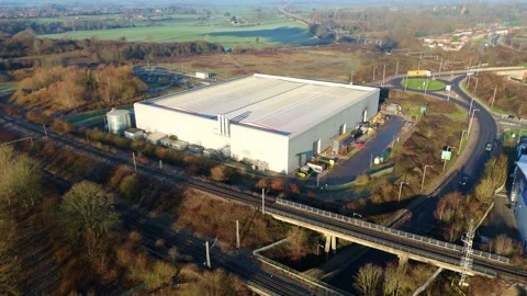 Sweeping aerial view of a massive distribution center and adjacent railway Stock Footage 333937806