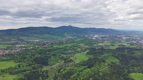 Sweeping aerial view over verdant valley with rolling hills, patchwork farms, Vídeo Stock 342355469