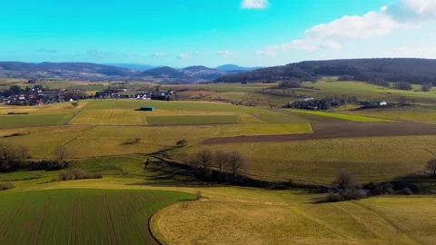 Sweeping Aerial View of Patchwork Farmland and a Quaint Village Stock Footage 271318726