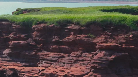 Sweeping around the windy cliffside at Duckpond Beach, Bay of Fundy in Stock Footage 289081225