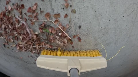 Sweeping with broom some leaves and debris during yard maintenance at home Stock Footage 346167784