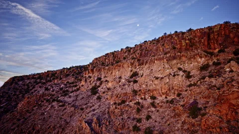 Sweeping cinematic drone shot over jagged crimson canyon cliffs in New Mexico Stockbeeldmateriaal 333415925