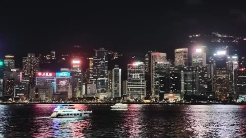 A sweeping, continuous night view from across the Victoria Harbour in Hong 库存影片 338280477