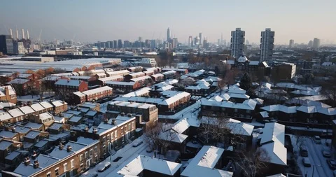 Sweeping drone clip of snow covered buildings in South West London, England. Видео 86498378