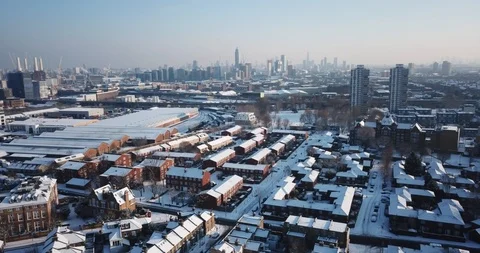 Sweeping drone clip of snow covered buildings in South West London, England. Видео 86498611