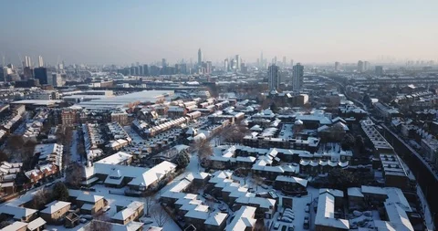 Sweeping drone clip of snow covered buildings in South West London, England. Stock Footage