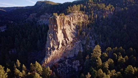 Sweeping drone flyover of dramatic cliff terrain with small tree clusters in Stock Footage 332620624