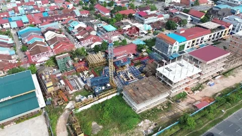 Sweeping drone perspective of a dynamic urban landscape with active construction 動画素材 320064304