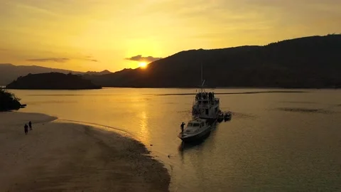 Sweeping Drone Shot of Boat During Sunset Surrounded By Indonesian Islands Stock Footage 133336714