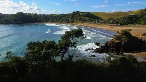 Sweeping drone shot of sandy bay with surfers Stock Footage 89570627