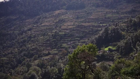 Sweeping high angle view over a misty terraced valley with patchwork farmland Stock Footage 343676736