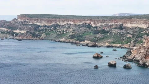 Sweeping limestone plateau cliffs layered rock strata calm bay offshore rock Stock Footage 343585111