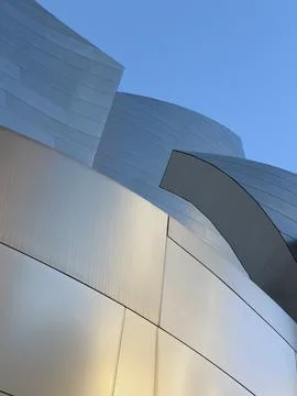 Sweeping metallic curves intersect with darker angular panels 스톡 사진
