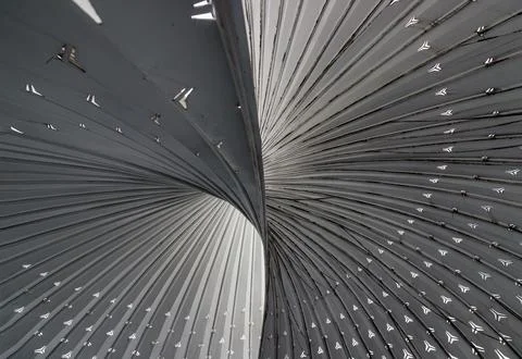 A sweeping, monochromatic vortex of metallic ribs twists elegantly across t.. Stock Photos