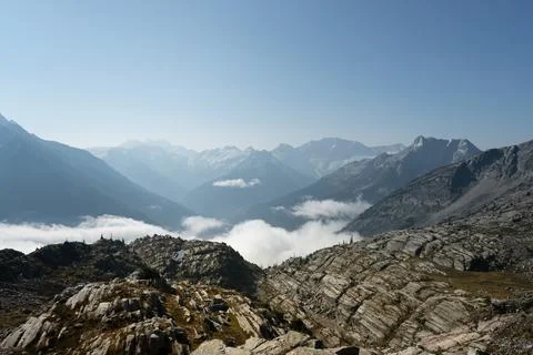 Sweeping mountain range vista with clouds filling the valley below view. Stock Photos