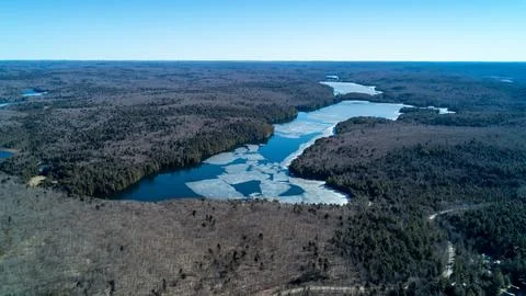 A sweeping panoramic drone photograph capturing a large winding lake with fra Stock Photos