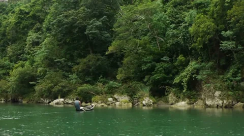 Sweeping past a man rowing a canoe near the lake shore. Stock Footage 32720238