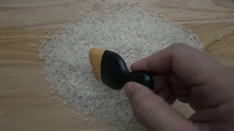 Sweeping Rice on wooden table Stock Footage 309593539