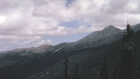 Sweeping Rocky Mountains Vista With Pine Forests And Highway 1960s 動画素材 347123901