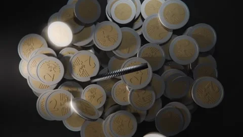 Sweeping rod striking pile, sending bimetal coins lifting, tumbling, scattering Stock Footage 337885990