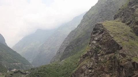 Sweeping shot moving down from Himalayan mountainside to steep rapids. Stock Footage 86758162