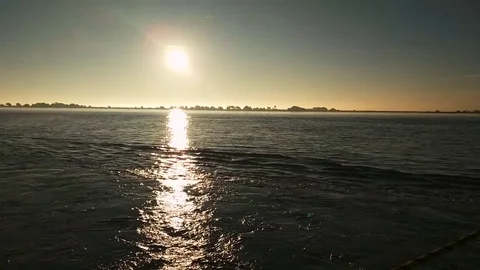 Sweeping shot of sunrise from boat in shipping channel Stock Footage