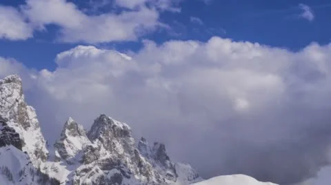 Sweeping timelapse of rolling clouds over a snowcapped mountain. Stock Footage 68300047