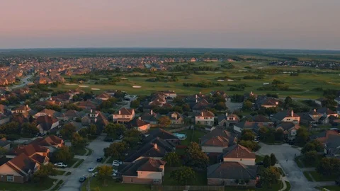 Sweeping tracking shot during Sunset over a Suburbia with Golf Course Stock Footage 114979965