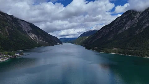 Sweeping View of Vast Mountain Lake Framed by Dark Forest Slopes Stock Footage 342579949