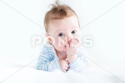 Sweet baby in a blue shirt sucking on its finger Stock Photos