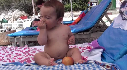Sweet baby eats apple at the beach 2, Crystal child Stock Footage 39912496