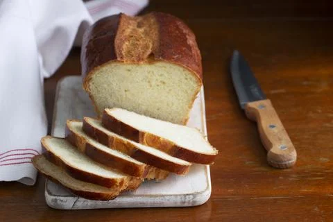 Sweet bread and slices of bread on a wooden table. Stock Photos