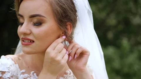 Sweet bride with a beautiful hair pulls on the earring. Stock Footage 85360621
