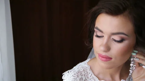 Sweet bride with a beautiful hair pulls on the earring. Stock Footage 87709672