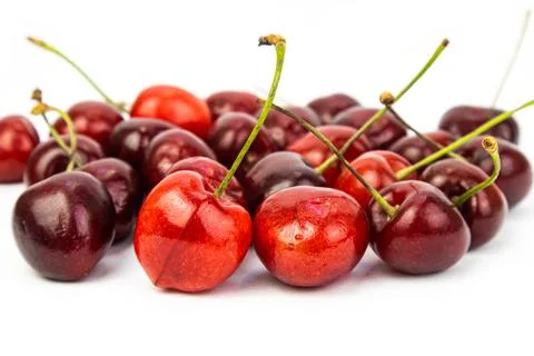Sweet cherry scattered on a white background, close-up. Seasonal berry harvest. Stock Photos