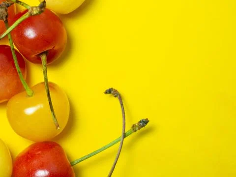 Sweet cherry with a stem on a yellow background. Bright table. Natural berrie Stock Photos