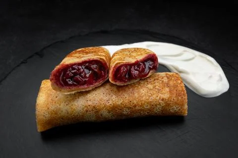 Sweet cherry stuffed fried blini Stock Photos