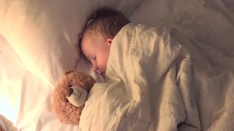 Sweet child with teddy bear toy friend sleeping together Stock Footage 41554591