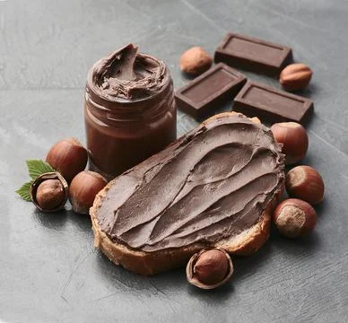 Sweet chocolate paste with hazelnuts nuts  and chocolate closeup. Stock Photos