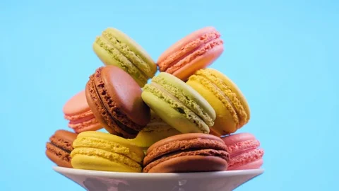 Sweet color macaroons on blue background. Slide from left to right Stock Footage 106984134