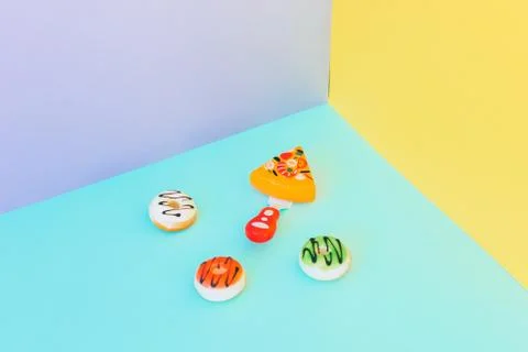 Sweet colorful donuts and slice of pizza Stock Photos