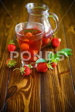 Sweet compote of ripe red strawberries in a glass decanter Stock Photos