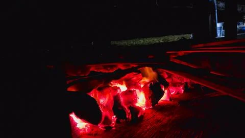 Sweet corn being roasted over red-hot charcoal embers. Stock Photos